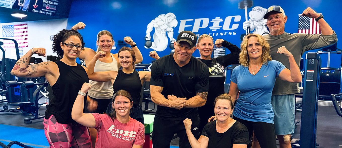 Bushnell Epic Fitness team strength photo—group of athletes flexing in front of an Epic Fitness gym logo, showcasing camaraderie, motivation, and dedication to fitness at the upcoming Bushnell location.